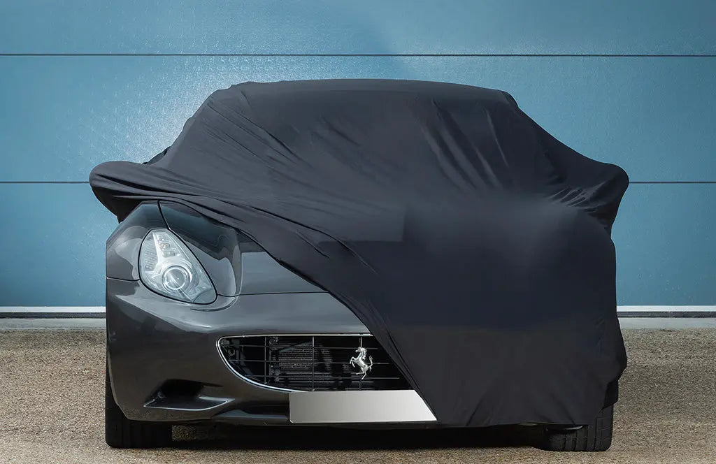 Ferrari car with a black outdoor car cover over the top with the front showing 