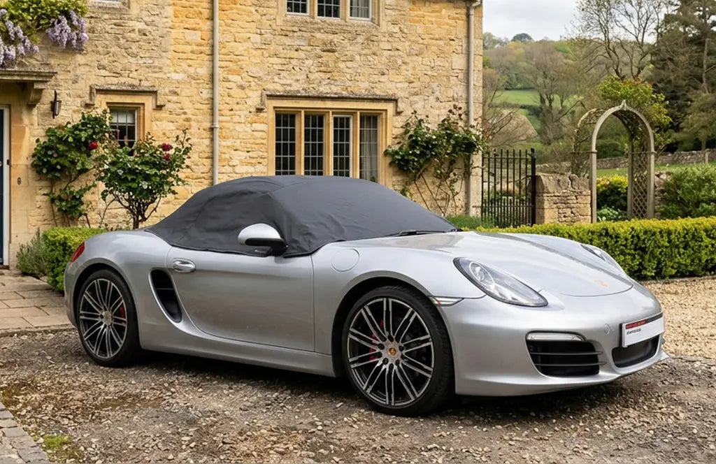 Porsche boxer with a half top car cover over the top protecting the roof 
