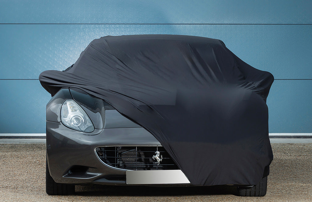 Ferrari car with a black outdoor car cover over the top with the front showing 