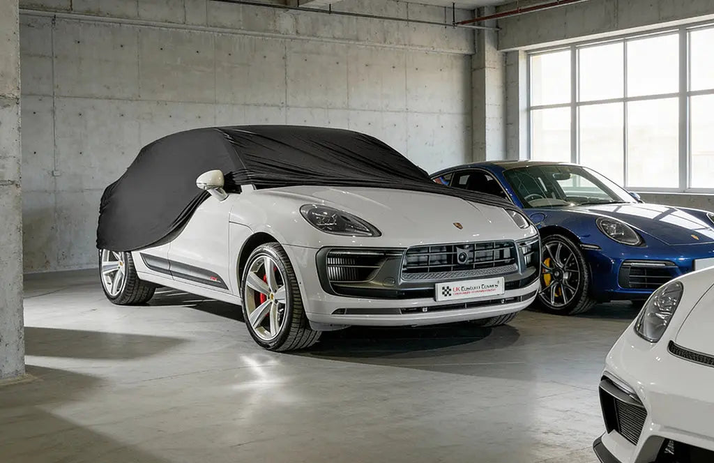 Porsche Macan in a garage with a black indoor car cover over the top showing the front of the car 